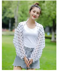 Detailed view of women's polka dot chiffon sun protection shrug in outdoor setting