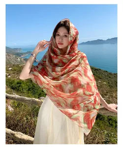 Detailed shot of a lightweight printed long scarf shawl featuring red and green swirl patterns