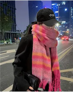 Close-up view of a pink and orange striped mohair-style scarf in an urban night scene