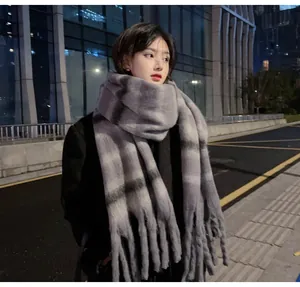 Soft grey and black striped plaid mohair scarf with thick tassels worn by a model