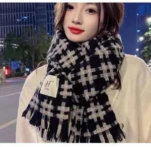 Close-up of a woman wearing a stylish black and beige crosshatch plaid winter scarf