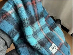 Close-up detail of soft Iceland blue plaid mohair scarf with brand label
