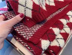 Macro view of red and white argyle knit scarf showing soft texture and detailed pattern