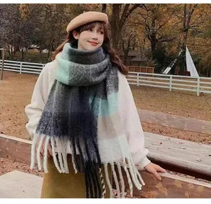 Close-up of soft mohair plaid scarf with tassels in a winter outdoor setting