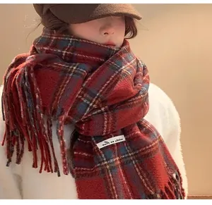 Close-up of a stylish red plaid cashmere scarf with fringes worn in a winter setting