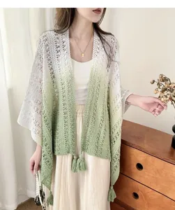 Elegant tie-dye gradient hollow knit shawl cape with tassel details on a model