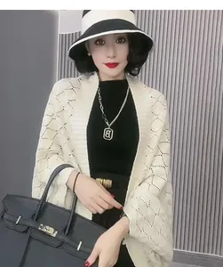 Detail of hollow diamond knit shawl cardigan cape for women in elegant cream white