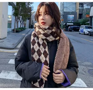 Detailed view of a woman wearing a brown diamond pattern knit scarf in a street setting