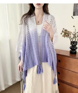 Detail view of a bohemian tie-dye gradient hollow-out knitted shawl with tassels