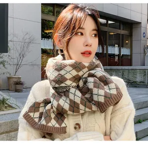 Detailed view of brown argyle knit scarf for women in a stylish outdoor setting