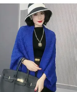 Detailed view of an elegant blue hollow diamond-patterned knit shawl cape for women