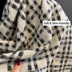 Close-up of a soft black and white checkered scarf with thick knit imitation cashmere texture
