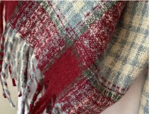 Detailed macro view showing the soft texture and red blue plaid pattern of faux cashmere scarf