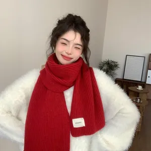 Cozy red ribbed knit winter scarf worn by a smiling Asian model in close-up view