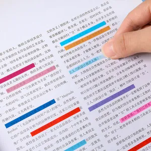 Onglets d'index en PET transparents colorés appliqués à la main sur une page de livre.