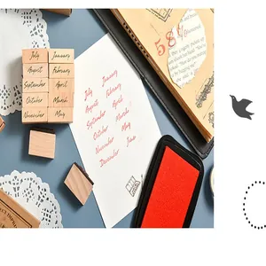 Close-up of wooden month stamps and red ink pad on a creative scrapbook page