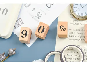 Detailed macro shot of wooden rubber stamps with number 60 and percent symbol on a desk.