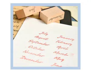 Detailed macro view of wooden month stamps showing red ink impressions on white card