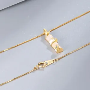 Gros plan d'un collier doré avec pendentif en bambou, cristaux et fermoir en argent S925