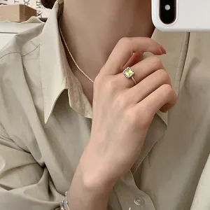 Close-up of elegant silver ring with rectangular green gemstone on finger