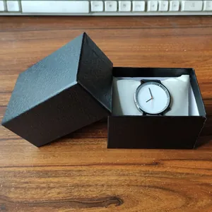 Minimalistische Herrenquarzuhr mit weißem Zifferblatt in einer schwarzen strukturierten Geschenkbox
