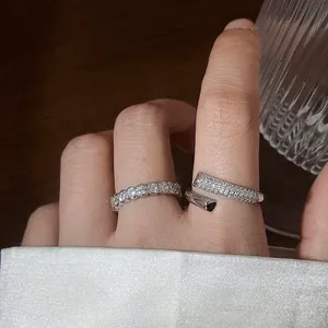 Primer plano de anillos abiertos de plata de ley 925 con circonitas de diseño elegante.