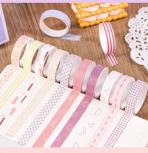 Detail view of assorted macaron colored washi tapes with vintage patterns on a notebook.