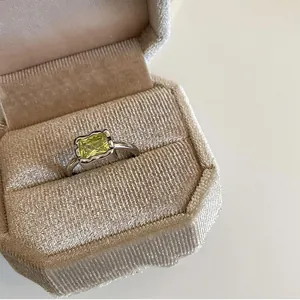 Detail of a light luxury green square stone ring presented in a velvet jewelry box