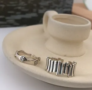 Minimalist sterling silver rings featuring smiley face and vertical ribbed bar design