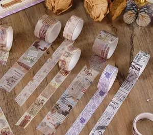 Detailed view of vintage washi tape rolls with newspaper and botanical patterns.