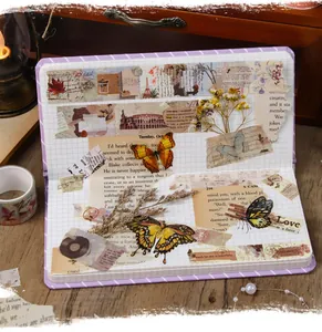 Close-up of vintage scrapbook stickers and washi tape applied in a grid notebook