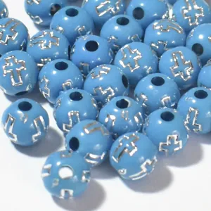 Close-up detail of 8mm blue acrylic round beads featuring silver cross engraving patterns