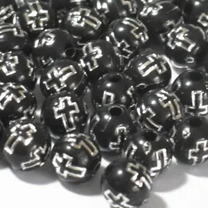 Close-up detail of 8mm black acrylic round loose beads with silver cross pattern