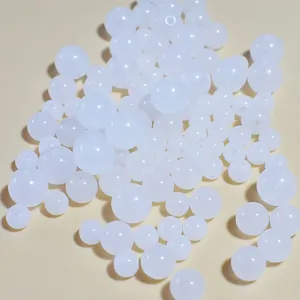 Close-up macro view of mixed size white acrylic jelly beads for DIY jewelry making crafts