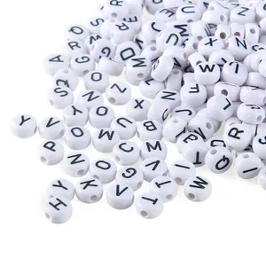 Macro detail of 4x7mm white acrylic flat round beads with black alphabet letters