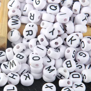 Macro view of white 4x7mm flat round acrylic alphabet beads for DIY jewelry craft projects