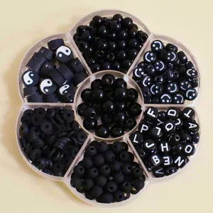 Nahaufnahme von schwarzen Acryl-Buchstaben und Smiley-Perlen in einer Blumenbox
