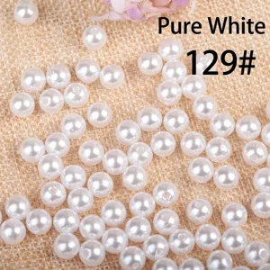 Close-up detail of white round acrylic pearls for DIY jewelry making accessories.