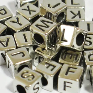 Close-up of 6mm silver acrylic cube beads with black engraved letters for DIY jewelry