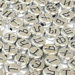 Primo piano di perle piatte in acrilico argento da 7 mm con lettere russe nere