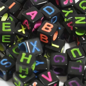 Close-up detail of 6mm black square acrylic alphabet beads for DIY jewelry making
