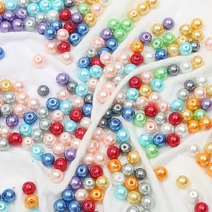 Macro di perle d'imitazione colorate di dimensioni miste su sfondo di tessuto bianco