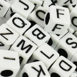Macro view of 6mm white acrylic cubic alphabet beads with black printed letters