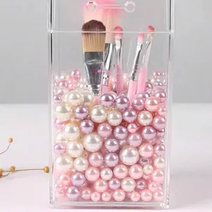 Dettaglio di perle finte rosa e bianche usate come riempitivo per portapennelli.