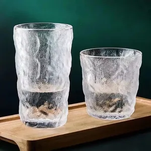 Transparent glacier texture glass cups for water and coffee set on a wooden tray