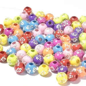 Macro detail of colorful acrylic beads with silver cross patterns for DIY jewelry making