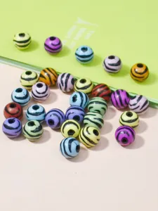 Primo piano di perline rotonde in acrilico colorato con strisce zebrate per il fai da te