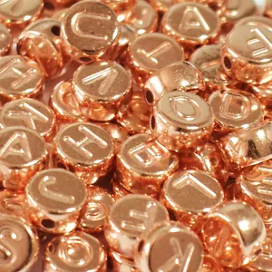 Close-up of 7mm rose gold acrylic beads with embossed English letters for DIY craft
