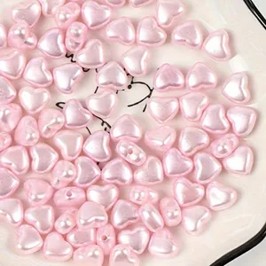 Close-up detail of 8mm pink heart-shaped faux pearl beads for DIY jewelry making.