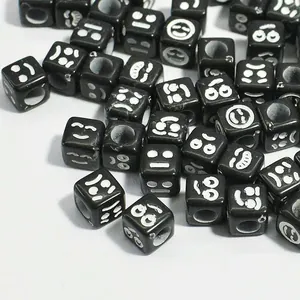 Detailed macro view of 6mm black square acrylic beads with white emoji face patterns